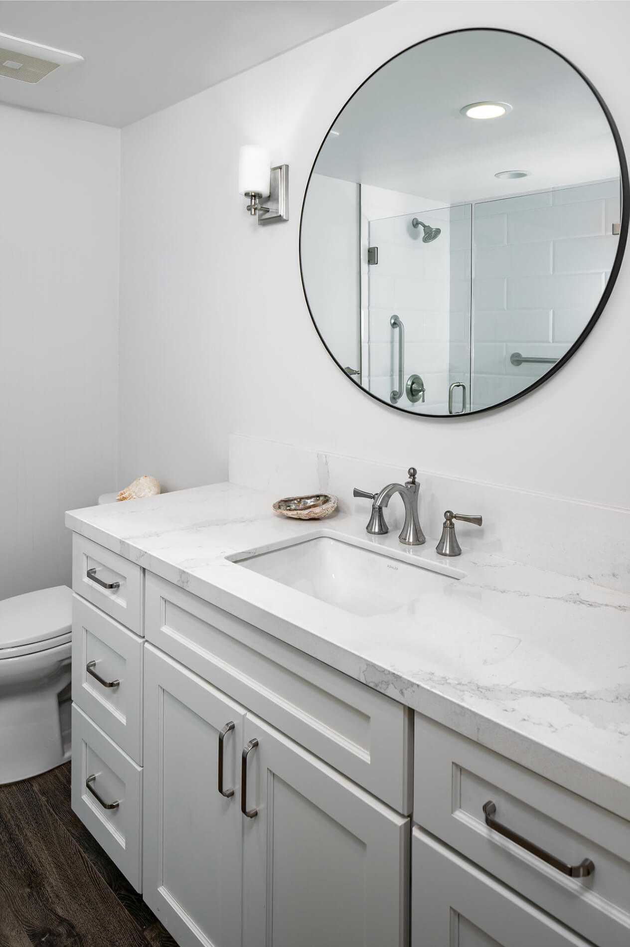 Bathroom Remodel – Sink with round mirror and white cabinets