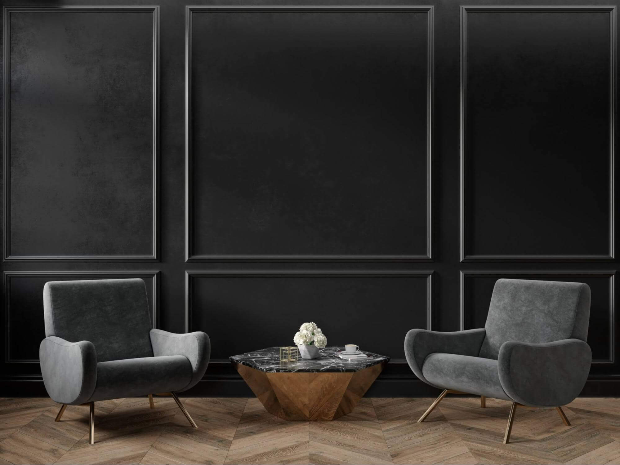 A dark painted room with two gray chairs and a marble-topped coffee table