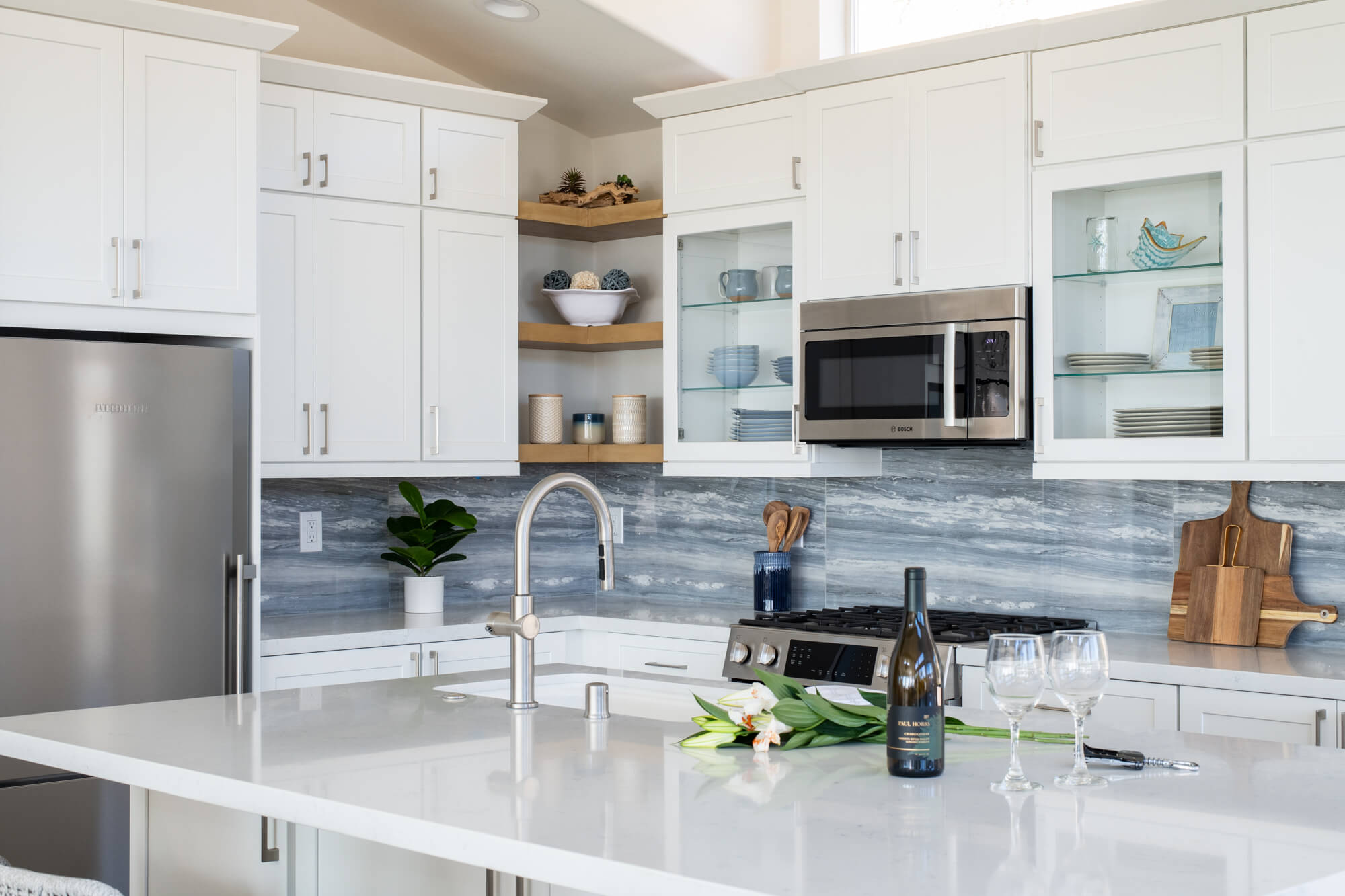 White-cabinetry-with-see-through-glass-shelving-in-kitchen-remodel