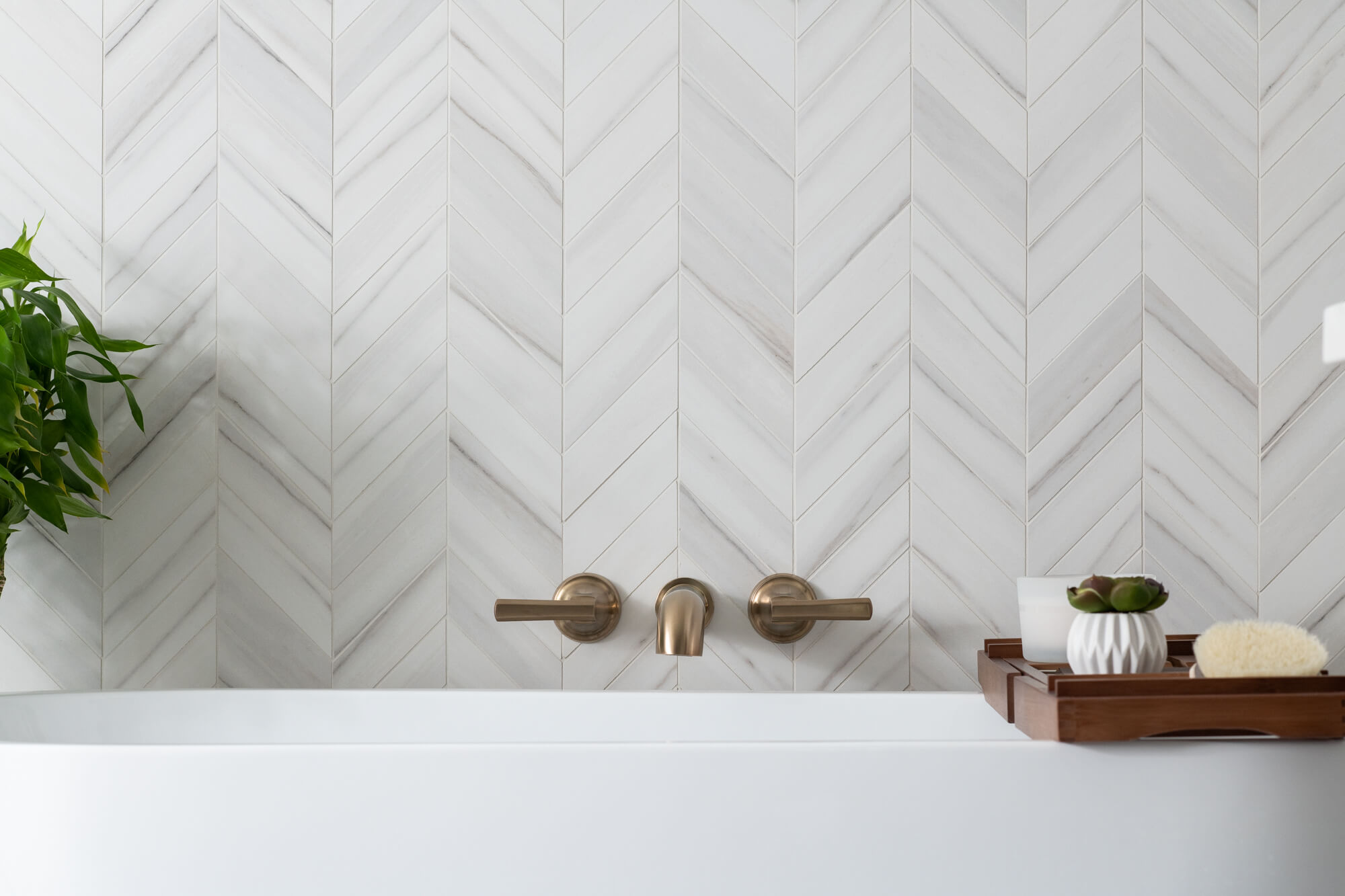 Freestanding tub with chevron style wall in bathroom remodel