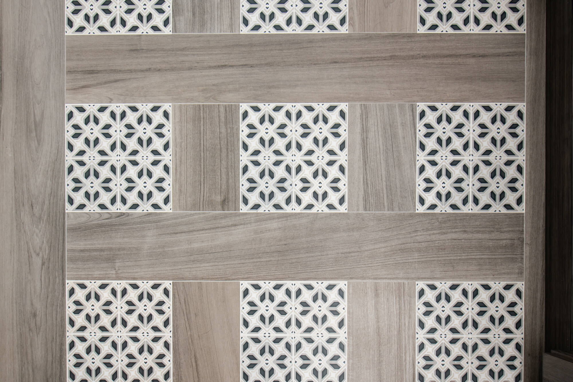 Porcelain Elysium flooring with patterned tile accents in bathroom remodel