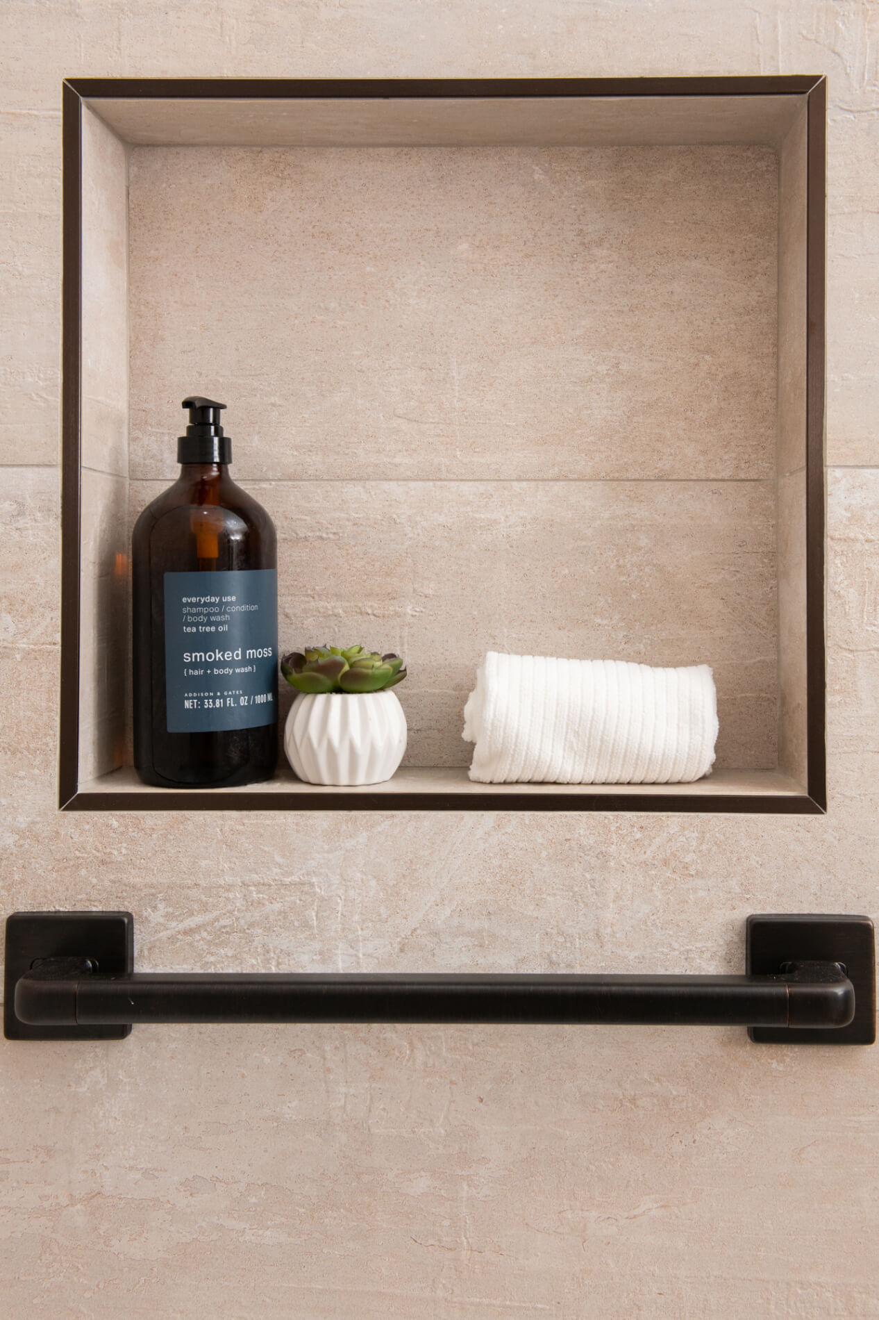 Accent shower wall with small shampoo niche and railings for aging in place design