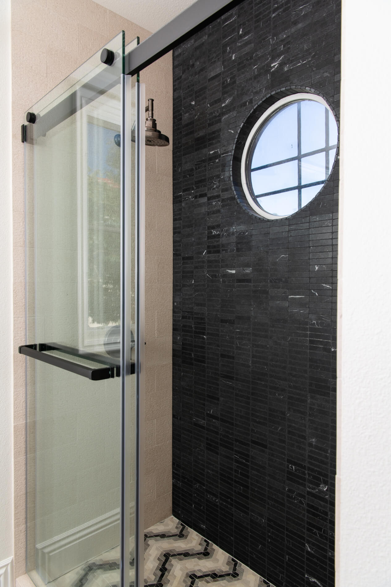 Bold limestone and marble shower tile with limestone flooring in bathroom remodel
