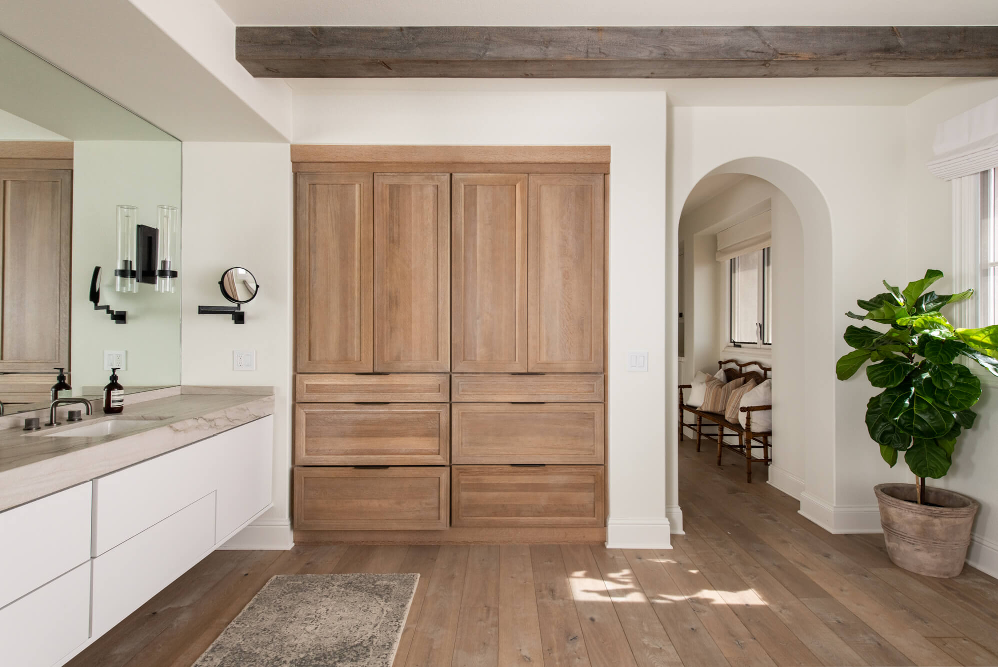 Custom built cabinetry for storing clothes in primary bathroom remodel