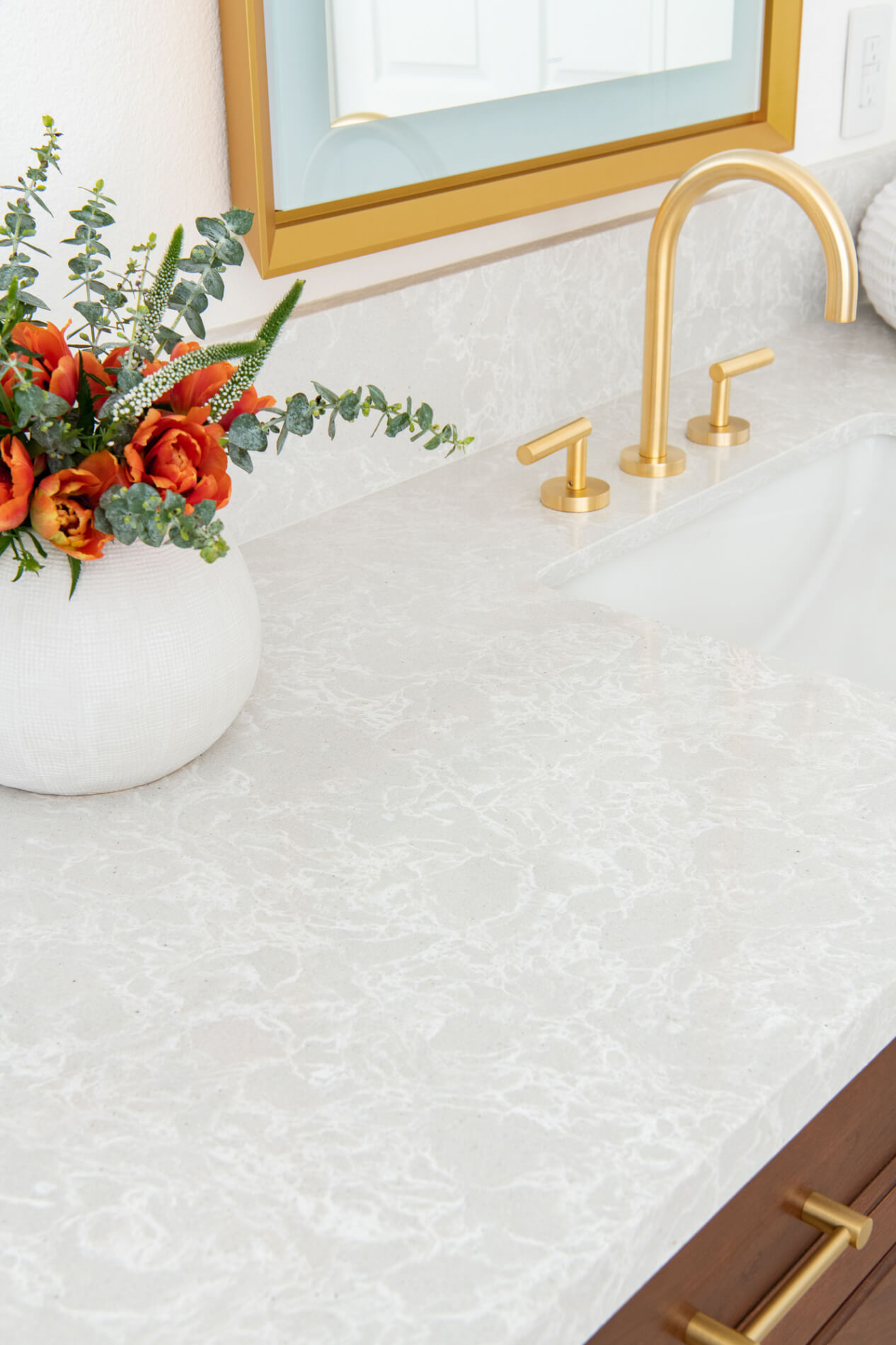 Quartz-countertop-with-gold-accent-fixtures-in-bathroom-remodel