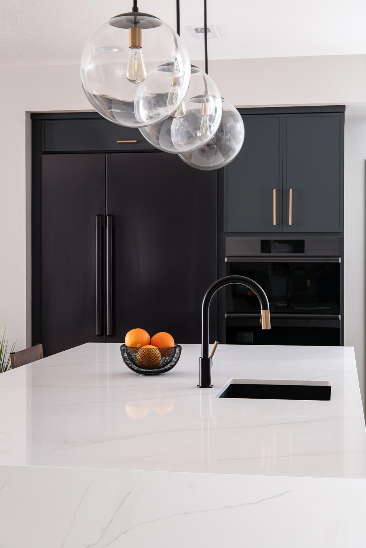 three-ceiling-pendants-over-quartz-countertop-kitchen-island