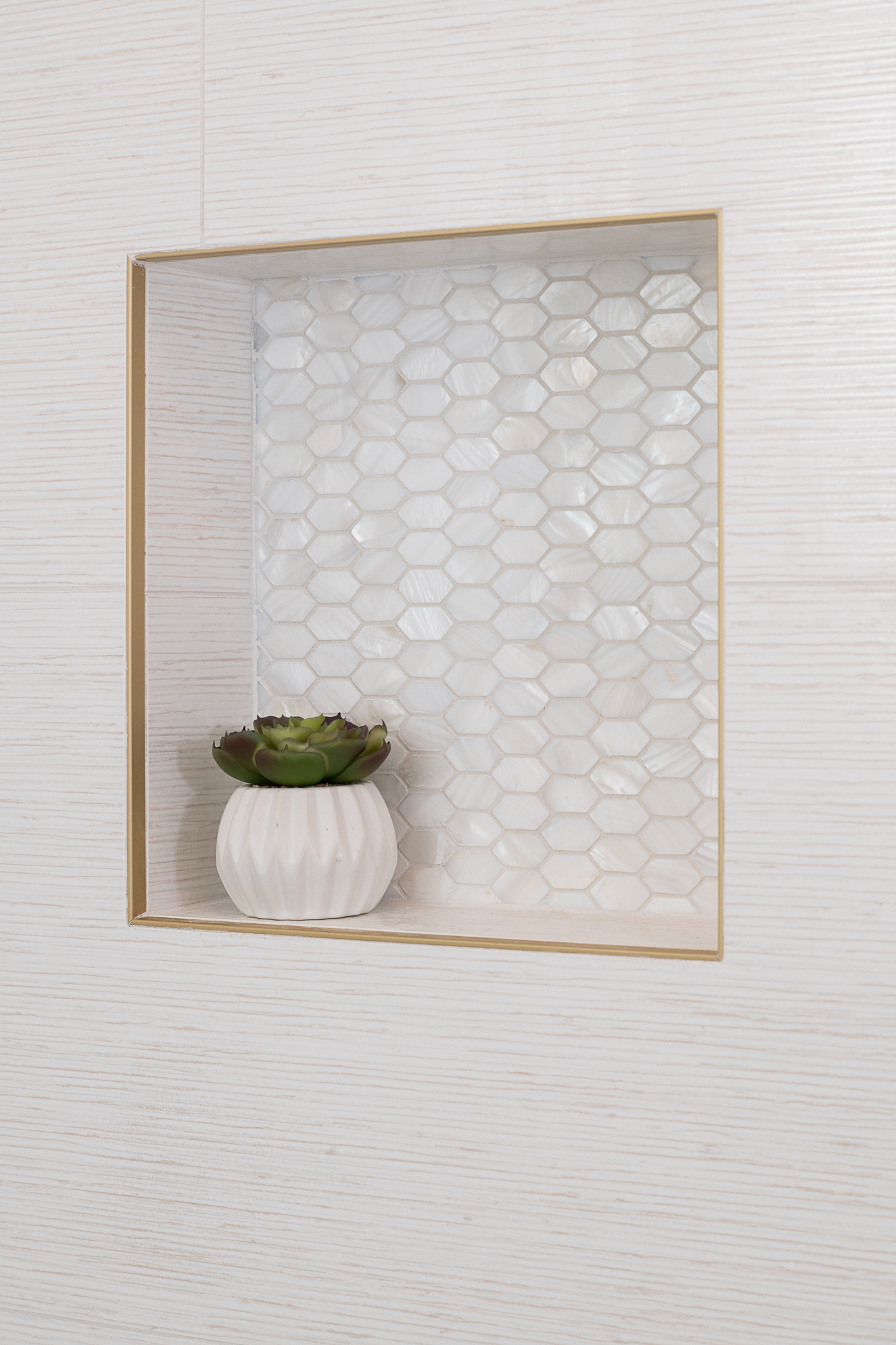 natural-stone-pearl-white-arrow-mosaic-shower-niche-with-satin-gold-trim