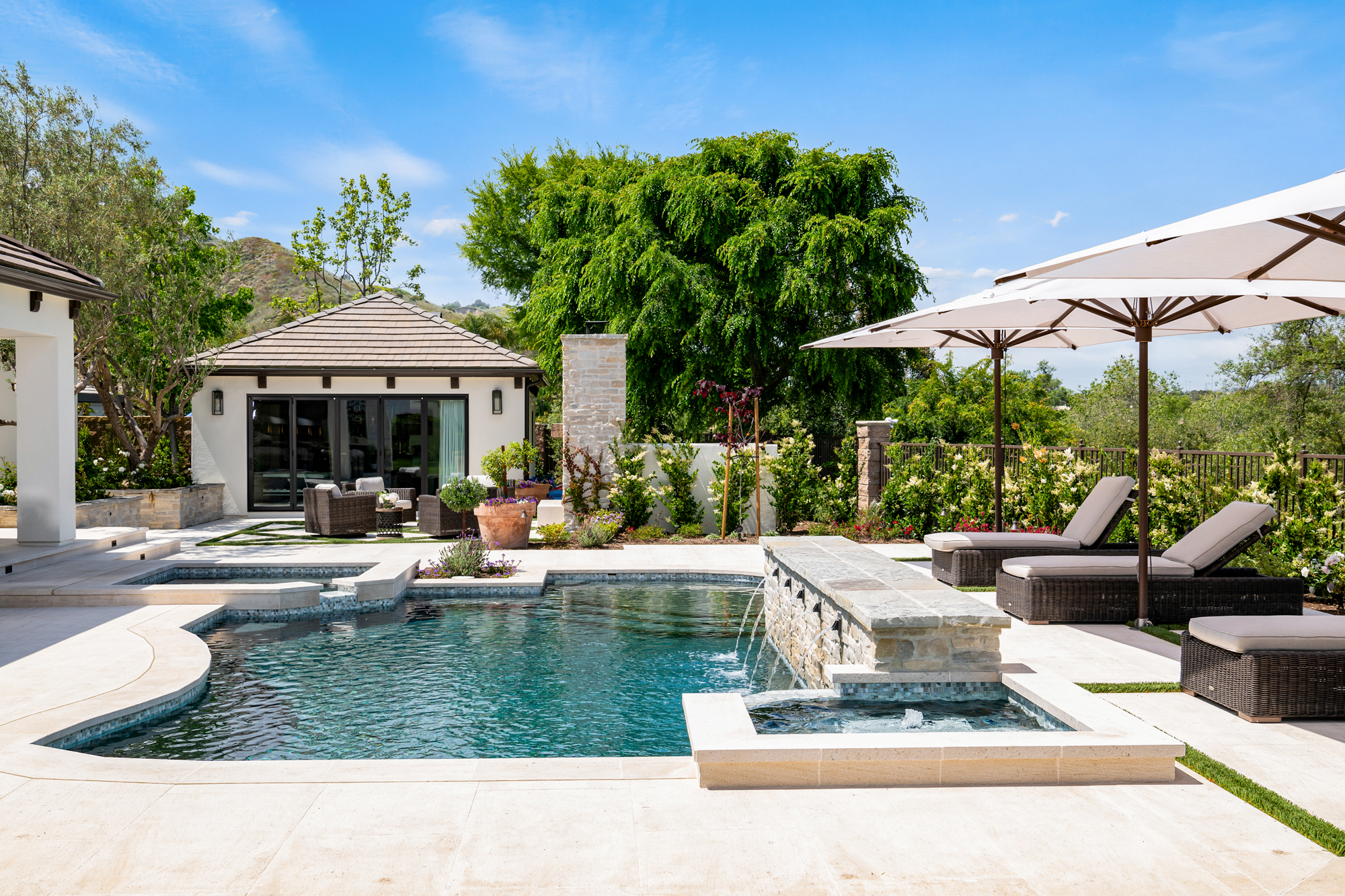 revamped-pool-house-fireplace-pool-wall-with-copper-spouts-and-limestone-veneer-wall