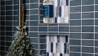 shower-niche-Elysium-glass-tile-backsplash-Newport-series-in-Arrow-Beach-vertical-pattern-with-polished-nickel-schluter-trim