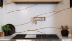 Silestone-quartz-backsplash-and-countertop-in-Eterna-D'or-with-gold-pot-filler