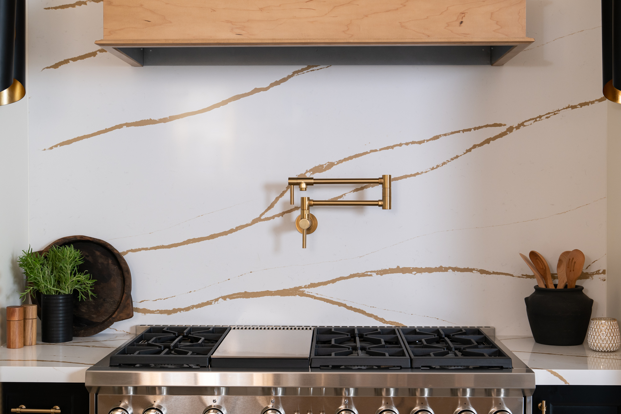Silestone-quartz-backsplash-and-countertop-in-Eterna-D'or-with-gold-pot-filler