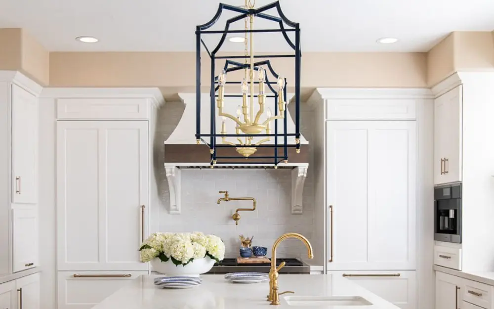 7-two-pendant-light-fixtures-in-blue-and-gold-sit-above-large-kitchen-island