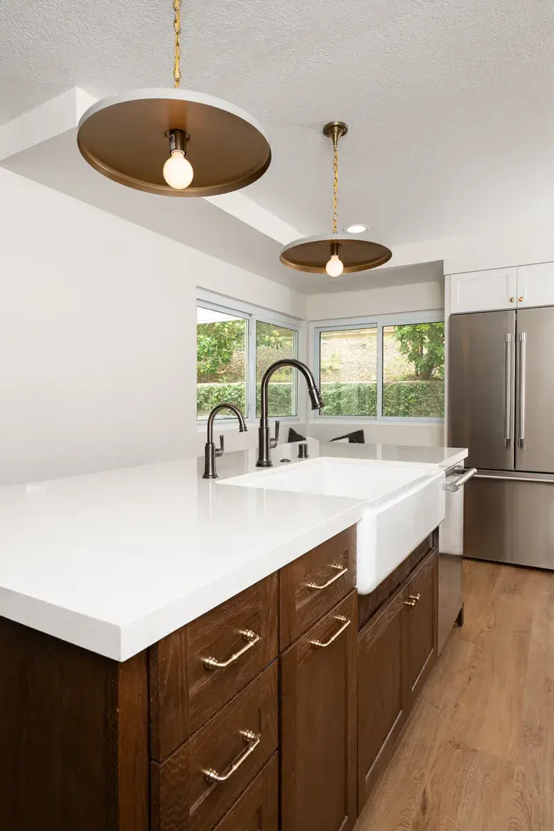 8-Sea-Pointe-Design-and-Remodel-2-bronze-and-tan-pendant-lights-above-island-with-white-farmhouse-sink