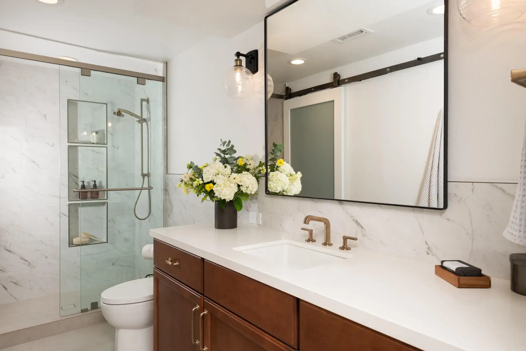 guest-bathroom-in-irvine-with-Emser-porcelain-tile-flooring-in-ivory-matte-and-Sea-Swell-Swing-Arm-Sconces-Black-Antique-brass
