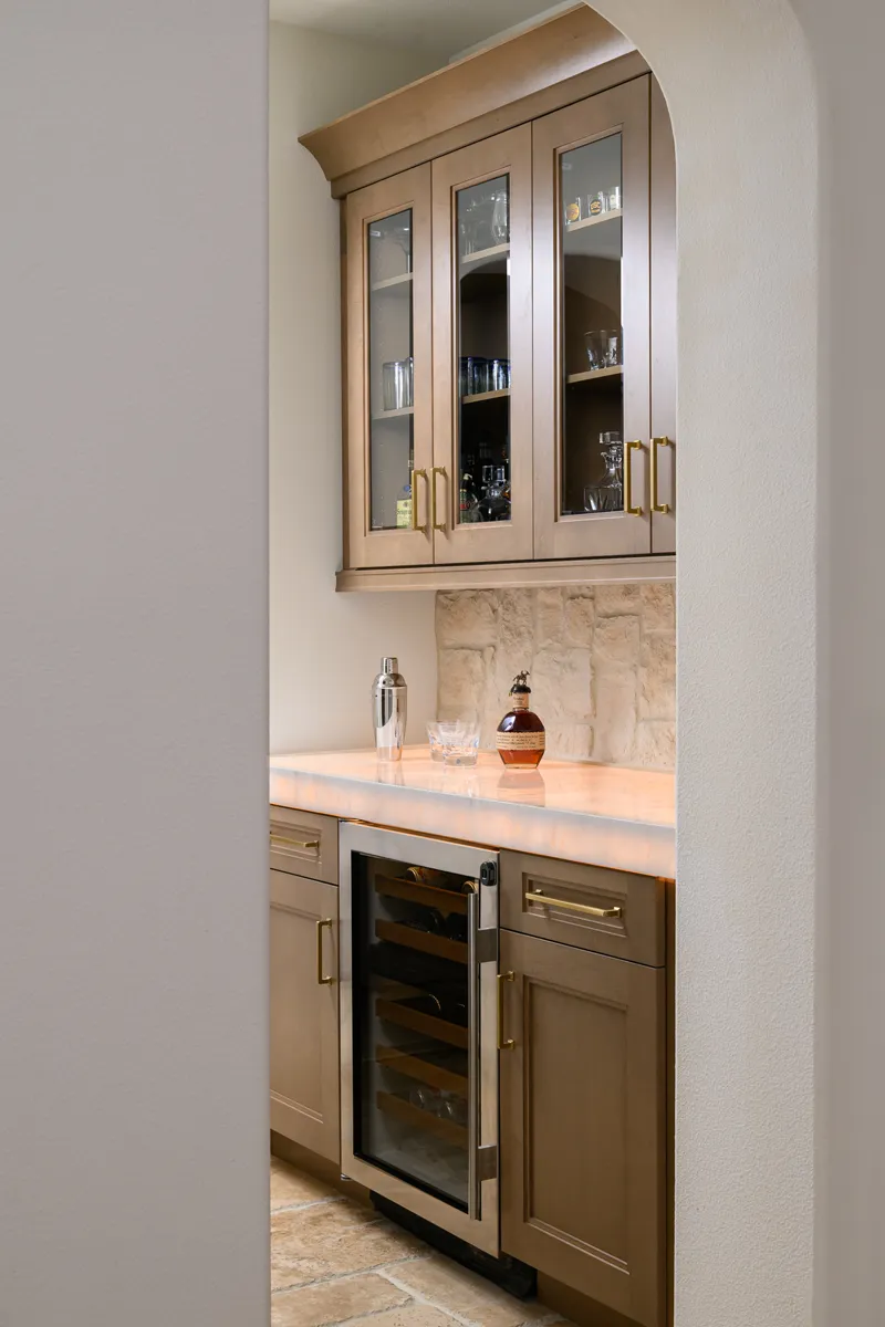 bar-area-includes-an-under-counter-beverage-fridge-and-glass-inserts-in-the-upper-cabinetry