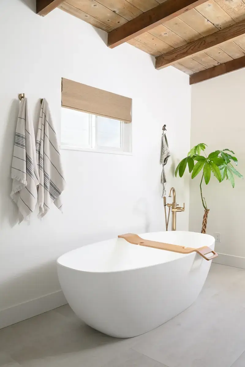 matte-white-freestanding-soaking-tub-with-single-handle-floor-mounted-tub-filler-with-handshower-in-chamapgne-bronze