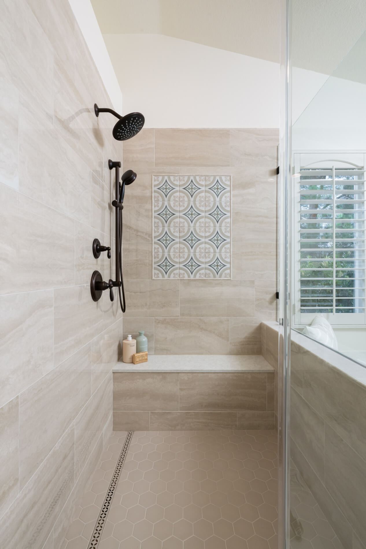 shower-head-and-handheld-shower-on-slide-bar-in-Orb-and-custom-glass-shower-enclosure-with-hinged-door