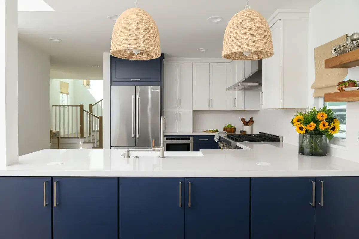two-beaded-light-pendants-sit-over-kitchen-peninsula-with-quartz-countertops-in-Miami-Versa-finish-with-a-light-polish