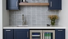 beverage-bar-cabinetry-matches-the-kitchen-and-includes-a-sink-and-beverage-fridge-plus-floating-shelves-to-add-aesthetic-appeal