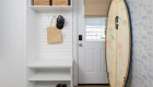 newly-added-mudroom-includes-a-white-door-with-a-window-and-storage-solutions-for-everyday-essentials