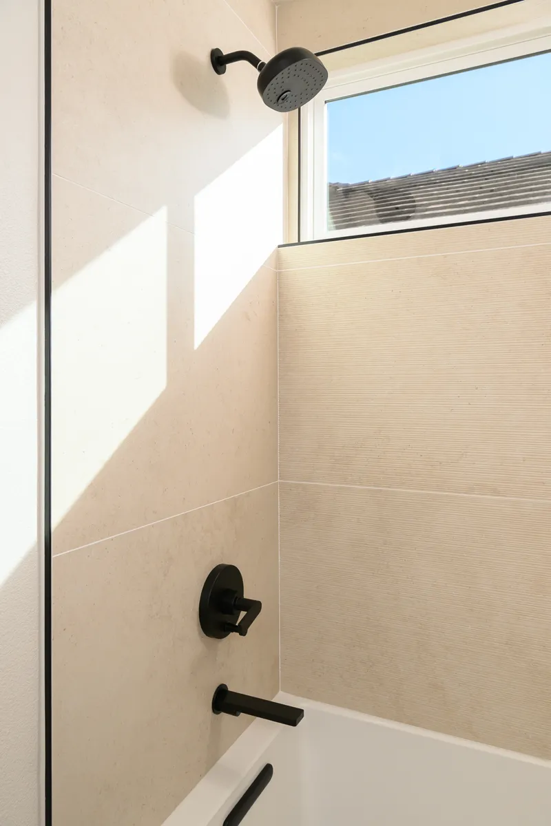 white-Alcove-bathtub-with-matte-black-showerhead-and-spout