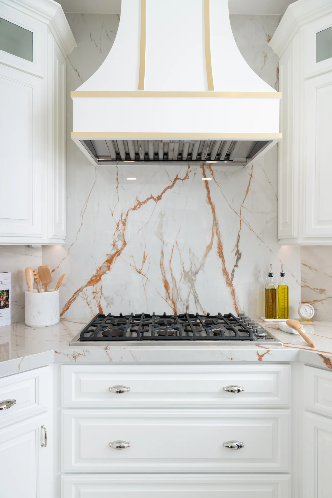 custom-white-curved-decorative-appliance-hood-with-brass-strappings