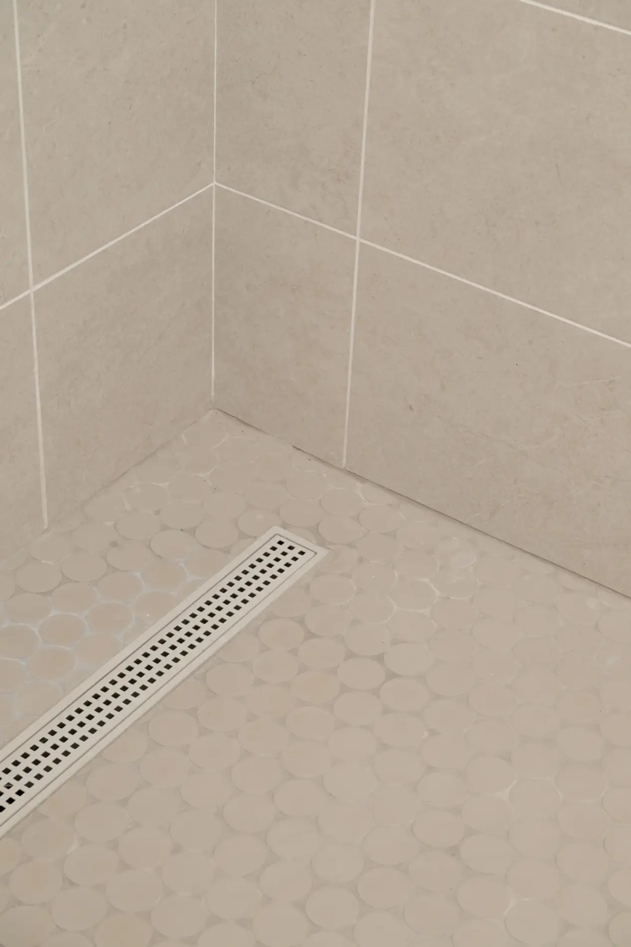 shower-pan-includes-a-linear drain-with-ceramic-floor-tiles-with-circle-design-in-Kumo-Gray-Matte-finish