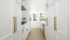 prep-kitchen-and-main-kitchen-perimeter-cabinetry-by-Kemper-in-white-finish-with-glass-inserts-and-Honey-Bronze-pulls