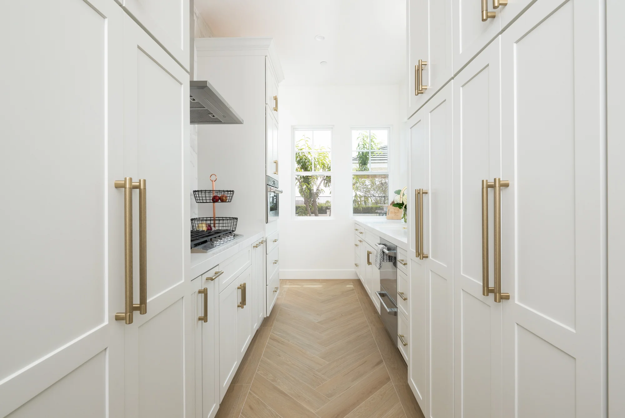 prep-kitchen-and-main-kitchen-perimeter-cabinetry-by-Kemper-in-white-finish-with-glass-inserts-and-Honey-Bronze-pulls