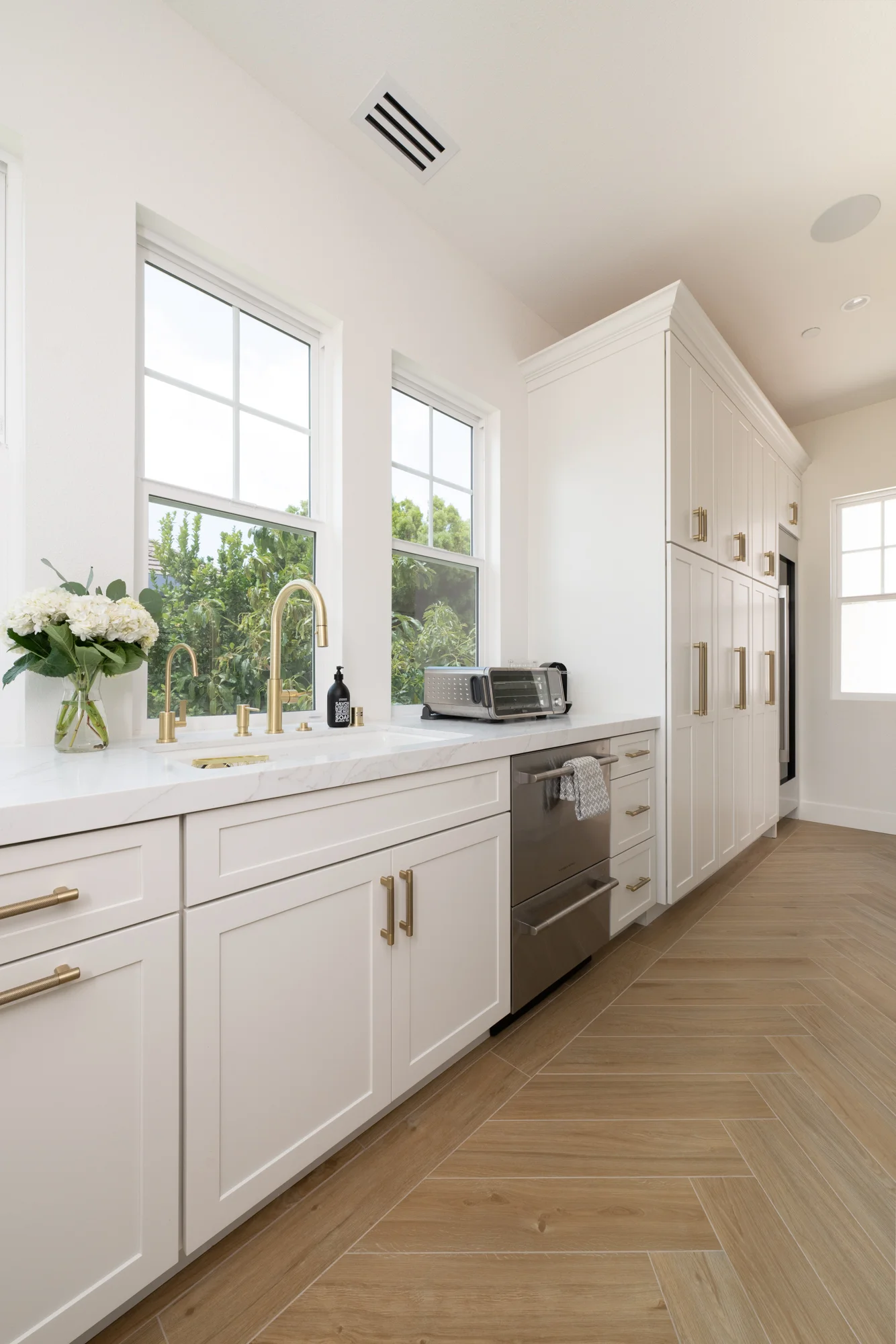 undermount-sink-with-satin-brass-high-spout-kitchen-faucet-in-back-kitchen