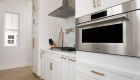 the-back-kitchen-includes-a-gas-cooktop-with-wall-mounted-hood-a-steam-oven-a-dishwasher-a-wine-cooler-a-beverage-cooler-and-pot-filler