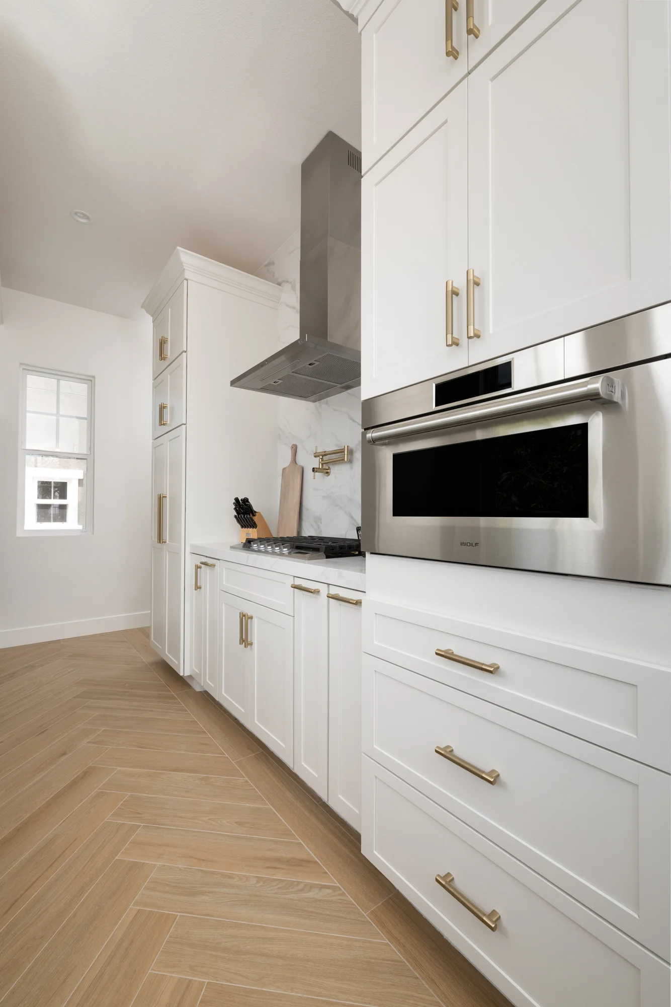 the-back-kitchen-includes-a-gas-cooktop-with-wall-mounted-hood-a-steam-oven-a-dishwasher-a-wine-cooler-a-beverage-cooler-and-pot-filler