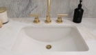 dual-vanities-include-white-undermount-sinks-with-widespread-lavatory-faucets-metal-framed-mirros-and-dual-sconces-in-satin-brass
